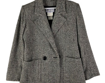 May include: A black and white houndstooth blazer with a double breasted closure and two flap pockets. The blazer has a black button and a label that reads "Yves Saint Laurent".