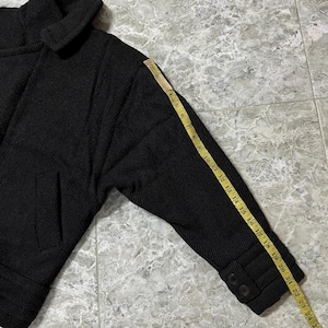 Puede incluir: Chaqueta negra con tejido texturizado, con cuello ancho y un solo bolsillo. La longitud de la manga es de aproximadamente 51 cm, medida con una cinta m&eacute;trica. La chaqueta tiene dos botones en el pu&ntilde;o.