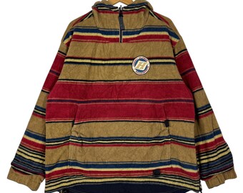 May include: A tan, red, and blue striped fleece pullover with a high collar and a quarter-zip closure. The jacket features a small patch with a logo on the chest and a front pocket. The fleece is soft and warm, perfect for cooler weather.