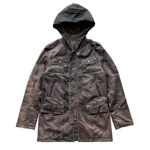 May include: Brown hooded jacket with multiple pockets and zippers. The jacket features a button-up front, a zip-up closure, and a leopard print lining in the hood. The jacket has a distressed, weathered appearance.