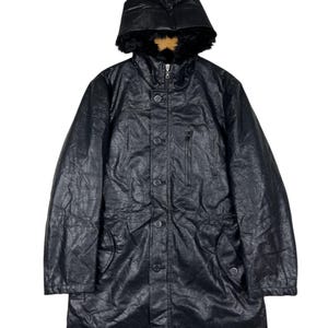 May include: Black winter coat with a hood trimmed with faux fur. The coat has a button-down front, a zipped chest pocket, and two side pockets. It is made from a textured, leather-look material.