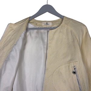 K&ouml;nnte beinhalten: Eine gelbe Jacke mit wei&szlig;em Muster und Rei&szlig;verschluss. Die Jacke hat eine kleine Tasche auf der linken Seite und ein Etikett mit der Aufschrift "GOLF WANG" auf der Innenseite.