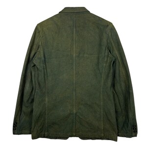 May include: A dark olive green blazer with a two-button closure and three buttons on each cuff. The jacket has a classic notched lapel and a tailored fit. The fabric appears to have a slightly worn or distressed look.