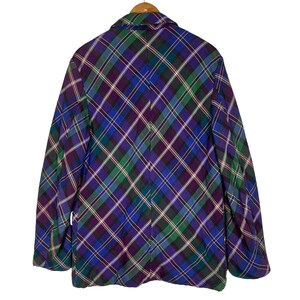 Puede incluir: Una chaqueta de cuadros en morado, verde y azul con cierre de botones.