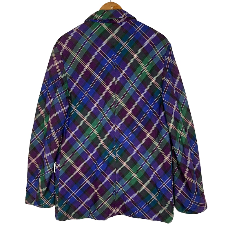 Puede incluir: Una chaqueta de cuadros en morado, verde y azul con cierre de botones.