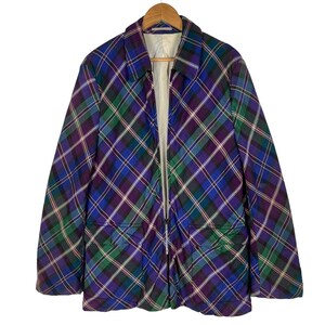 Puede incluir: Una chaqueta acolchada con un patr&oacute;n de cuadros en tonos de azul, verde, morado y blanco. La chaqueta tiene una cremallera y dos bolsillos.