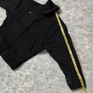 Puede incluir: Una taza de cer&aacute;mica blanca con un asa negra y el texto "But First, Coffee" en negrita negra. La taza est&aacute; sobre un fondo borroso. La taza mide aproximadamente 10 cm de altura.