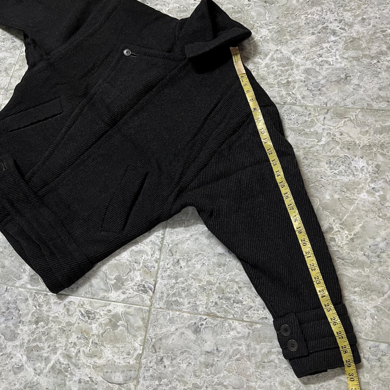 Puede incluir: Una taza de cer&aacute;mica blanca con un asa negra y el texto "But First, Coffee" en negrita negra. La taza est&aacute; sobre un fondo borroso. La taza mide aproximadamente 10 cm de altura.