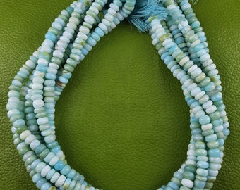 Könnte beinhalten: Eine Strähne aus hellblauen und weißen Opalperlen. Die Perlen sind klein und rund und auf einer dünnen Schnur aufgefädelt. Die Strähne ist etwa 46 cm lang.