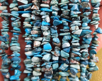 May include: A strand of turquoise chip beads, featuring a mix of blue and green hues with brown marbling. The chips are irregular in shape and size, creating a natural and rustic look.