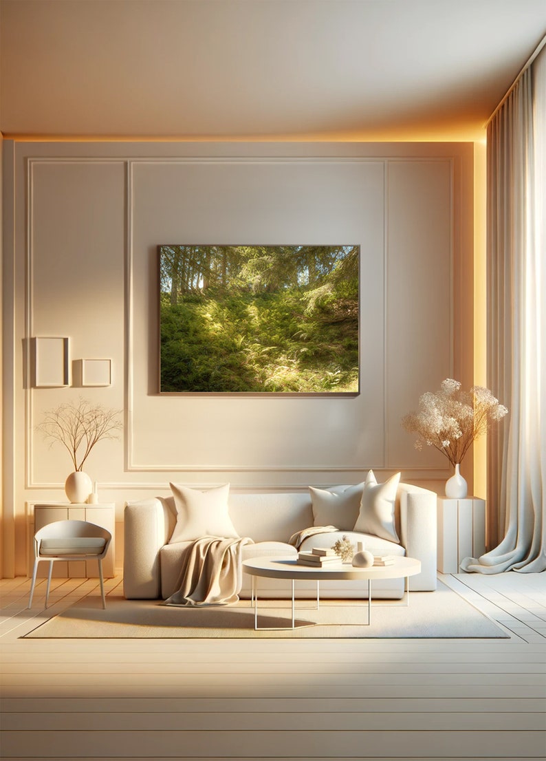 May include: A white sofa with two pillows and a throw blanket sits in a living room with a white coffee table and a framed print of a green forest scene on the wall.