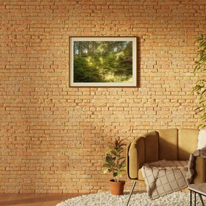 May include: A brown armchair with a white throw blanket sits in front of a brick wall. A framed picture of a forest scene hangs on the wall. A potted plant sits on the floor next to the chair.