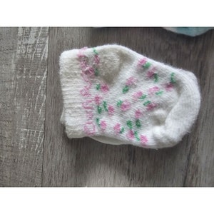 Puede incluir: Un calcet&iacute;n blanco con un estampado floral rosa y verde.