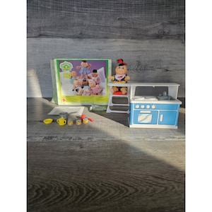 以下が含まれることがあります： キャベツパッチキッズのプレイセット。青と白のキッチン、白いハイチェア、ハイチェアに座っているキャベツパッチキッズのドール。キッチンには、コンロ、シンク、カウンターがあります。セットには、小さな鍋、ティーポット、小さな缶が3つ含まれています。