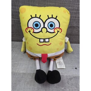 May include: A plush yellow SpongeBob SquarePants character doll. The doll has large blue eyes, a red tie, and black shoes. The doll is approximately 10 inches tall.