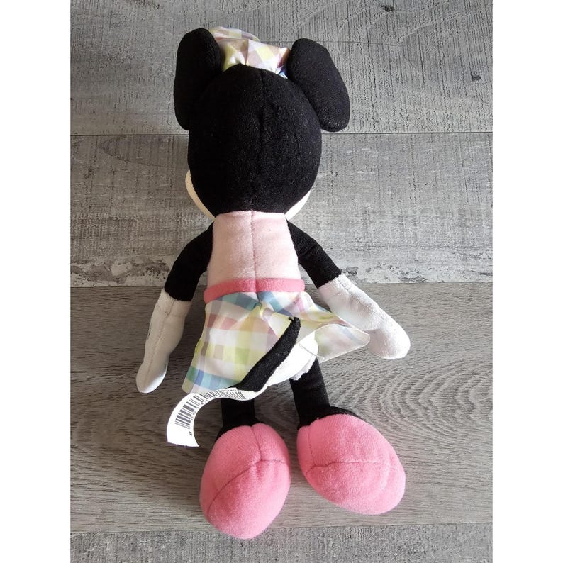 K&ouml;nnte beinhalten: Ein Pl&uuml;schtier von Minnie Mouse, die ein rosa Kleid mit einem karierten Rock und einer rosa Schleife auf dem Kopf tr&auml;gt.