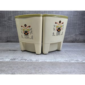 May include: A white ceramic mug with a black handle and the text "But First, Coffee" in a black, handwritten-style font. The mug is on a white surface.