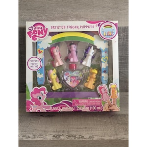 May include: A My Little Pony bathtub finger puppet set. The box includes six colorful pony finger puppets, a heart-shaped bubble bath bottle, and the text "PUPPETS SQUIRT WATER!". The set is designed for children aged 3 and up.