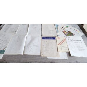 Puede incluir: Una colección de patrones de costura y plantillas para acolchar. Los patrones incluyen una variedad de formas, incluyendo triángulos, cuadrados y círculos. Las plantillas están hechas de plástico transparente y están etiquetadas con el tamaño y la forma de cada pieza. Los patrones están impresos en papel blanco y están etiquetados con el nombre del patrón y el diseñador. El texto en los patrones incluye "Pullout Pattern Sections", "White Crafts", "QuickTemplates", y "Hold Fast That Hold -  Great Bear Stitch".