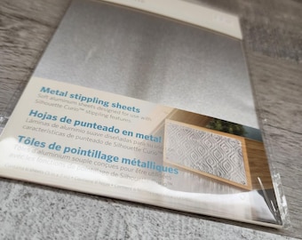 Könnte beinhalten: Eine Packung mit sechs silberfarbenen Metall-Stippling-Blättern für die Silhouette Curio. Die Verpackung enthält den Text Metal stippling sheets, Hojas de punteado en metal und Tôles de pointillage métalliques sowie eine 12,7 cm x 17,8 cm Angabe.