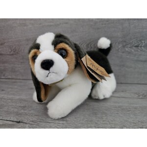 May include: A plush black, brown, and white beagle puppy toy with a brown collar. The toy has a tag that says "My First Beagle".