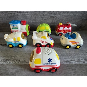 May include: A collection of colorful toy vehicles, including a train, airplane, race car, fire truck, ambulance, van, and convertible. Each toy is brightly colored with details like wheels and text labels.