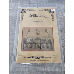Könnte beinhalten: Ein braunes Papier-Kreuzstichmuster mit einer Schwarzweißillustration eines kleinen Steinhauses mit einem weißen Lattenzaun. Der Text "Silkstone Design" und "Stonehaven" ist auf dem Muster gedruckt. Das Muster ist mit "SDC27" und "Chart Only" gekennzeichnet.