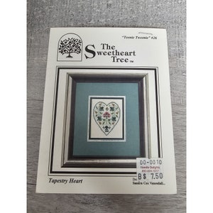 May include: A cross-stitch pattern for a heart-shaped tapestry with a floral design. The pattern is titled "Tapestry Heart" and is from "The Sweetheart Tree" needlework company. The pattern is priced at $7.50.