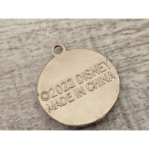May include: Silver-colored round charm with the text "&copy;2022 DISNEY MADE IN CHINA" on the back.