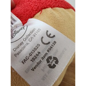 May include: White tag with black text that reads "Disney Collection Pasadena, CA 91105 FAC-013525 15244 CE Vendor item #04128". The tag has a recycling symbol with the text "100%" inside.