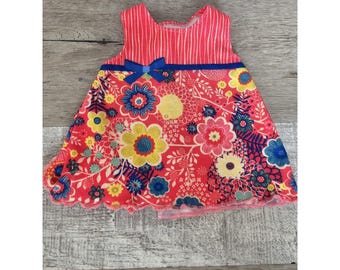 May include: A sleeveless red dress with a floral print and a blue bow. The dress has a scalloped hem and a striped bodice.