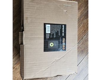 Puede incluir: Una caja de cartón marrón con una etiqueta blanca. La etiqueta tiene el texto "TL-3BO TECk" y "SPWZ/W-65" impreso en ella. La etiqueta también presenta una pequeña imagen de un altavoz negro con un cono de altavoz amarillo.