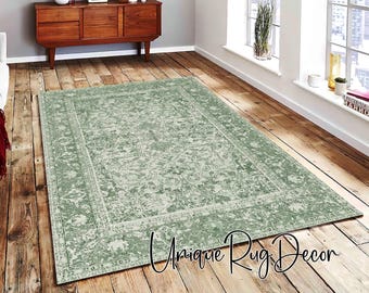 May include: A rectangular, distressed-look rug in shades of green and cream, with a detailed floral pattern and a decorative border. The rug is placed on a wooden floor, with the text "Unique Rug Decor" in the bottom right corner.