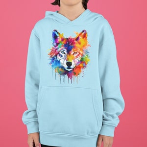 May include: A light blue hooded sweatshirt featuring a colourful watercolour wolf design on the front. The wolf's face is detailed with a black nose and eyes.