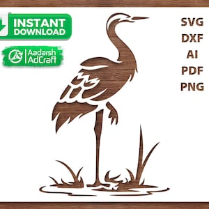 Puede incluir: Un recorte de madera marrón de una garza de pie en el agua con hierba. La imagen incluye el texto "Descarga instantánea" y el logotipo de Aadarsh AdCraft. Los formatos de archivo incluyen SVG, DXF, AI, PDF y PNG.