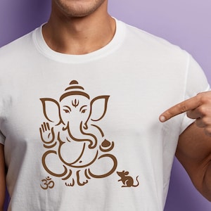 May include: White t-shirt featuring a brown illustration of the Hindu deity Ganesha in a seated pose, with an Om symbol and a mouse. The design is centered on the shirt.