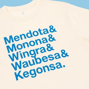 May include: A white t-shirt with blue text that reads "Mendota & Monona & Wingra & Waubesa & Kegonsa."