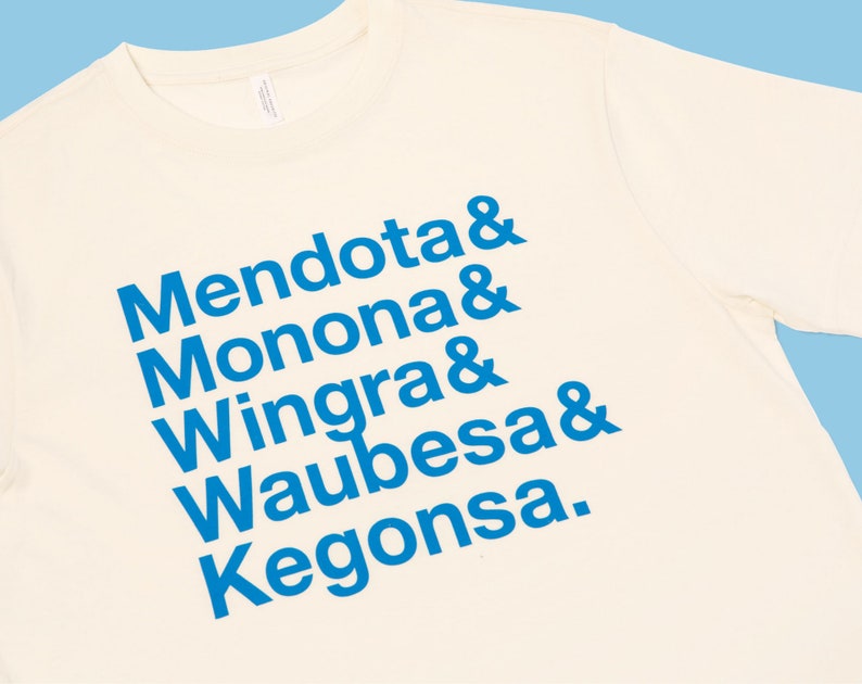 May include: A white t-shirt with blue text that reads "Mendota & Monona & Wingra & Waubesa & Kegonsa."