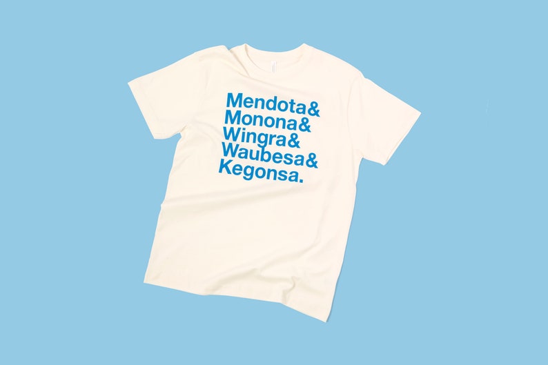 May include: A white t-shirt with blue text that reads "Mendota & Monona & Wingra & Waubesa & Kegonsa."