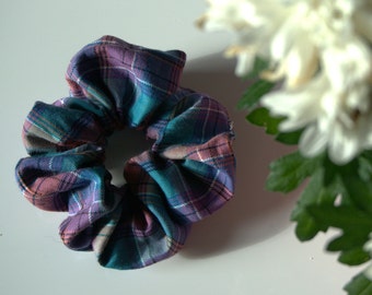 May include: A teal, purple, and pink plaid scrunchie.
