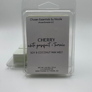 May include: A white square wax melt with the text "CHERRY white grapefruit + Tumeric SOY & COCONUT WAX MELT" and "NET WT. 2.5 OZ / 70 G 8-10 HOURS BURN TIME HAND POURED IN TYRONE, GA".