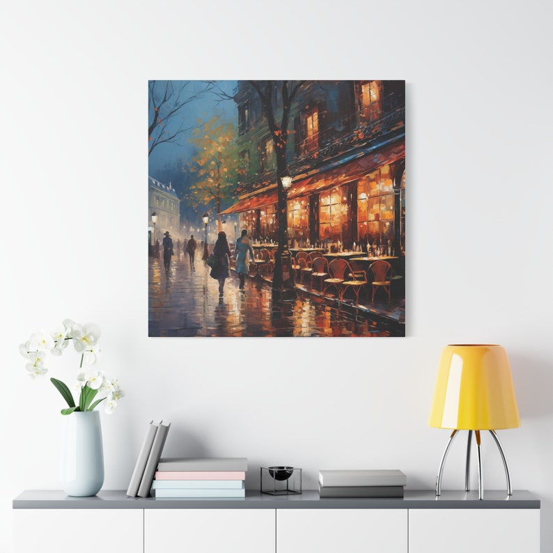 Puede incluir: Una pintura de una escena callejera parisina de noche, con un caf&eacute; en el lado derecho de la imagen. El caf&eacute; tiene un toldo rojo y est&aacute; iluminado con luces amarillas c&aacute;lidas. Hay gente caminando por la calle, y el suelo est&aacute; mojado por la lluvia.