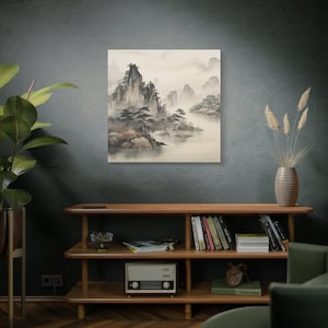 K&ouml;nnte beinhalten: Ein Schwarzwei&szlig;bild einer nebeligen Berglandschaft mit einem kleinen Dorf in der Ferne. Das Bild ist gerahmt und h&auml;ngt an einer dunkelgrauen Wand.