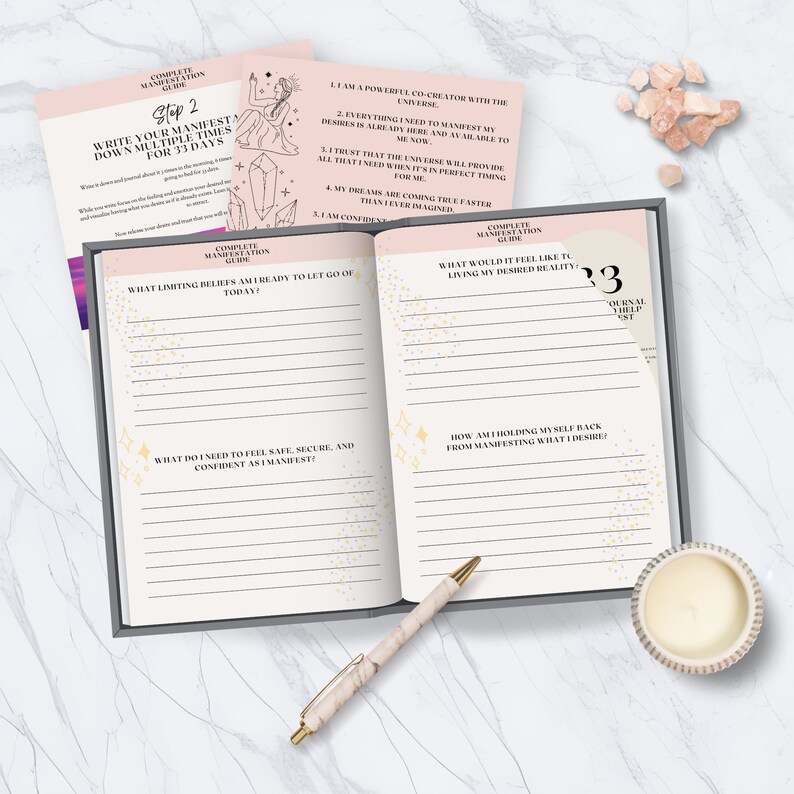 May include: A pink and white journal with gold stars and glitter. The journal has a section for writing down limiting beliefs and a section for writing down what you need to feel safe, secure, and confident as you manifest. The journal also has a section for writing down what it would feel like to live in your desired reality and how you are holding yourself back from manifesting what you desire. The journal is titled "Complete Manifestation Guide" and has the number "33" on the cover.