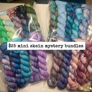 May include: Multiple bundles of colourful yarn skeins in clear plastic packaging. The skeins are in various shades of blue, green, purple, and red. Text on the image reads "$25 mini skein mystery bundles."