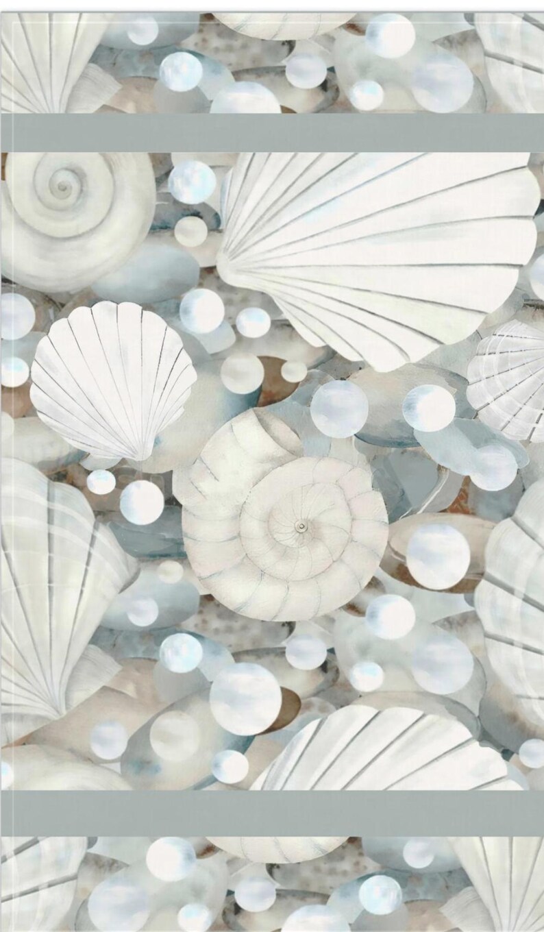 May include: A fabric pattern featuring a repeating illustration of white seashells and smooth, rounded gray stones interspersed with translucent white bubbles. The design includes various spiral and fan-shaped shells arranged in a dense, layered composition.