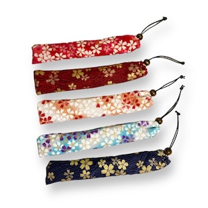 May include: Five fabric pouches with floral patterns and drawstrings. The pouches are in various colors, including red, pink, blue, and gold.