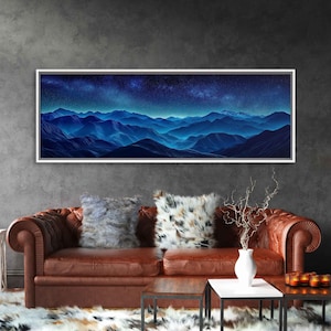 May include: A panoramic landscape painting of a mountain range under a starry night sky. The mountains are a deep blue color, and the sky is a dark blue with white stars. The painting is framed in a white frame.