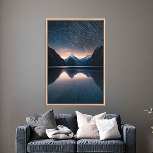 May include: A photograph of a mountain range reflected in a still lake at night. The sky is filled with star trails, creating a swirling pattern of light.