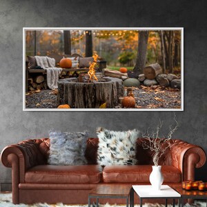 May include: A framed photograph of a rustic outdoor fire pit with a roaring fire, surrounded by pumpkins and fall foliage. The fire pit is made of a large, weathered tree trunk.